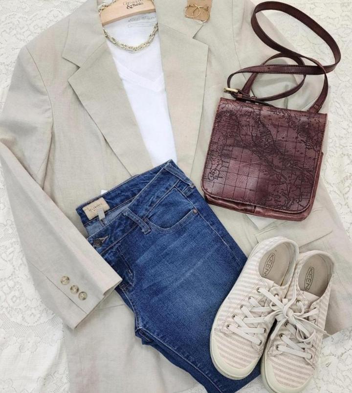 Blue jeans, beige blazer, brown purse, and matching shoes and accessories.